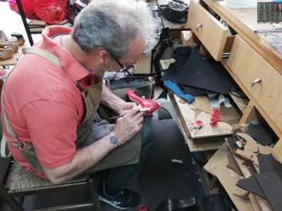 Mentre Augusto dipinge di rosso un paio di ballerine, ci racconta la fatica che c�� dietro al lavoro